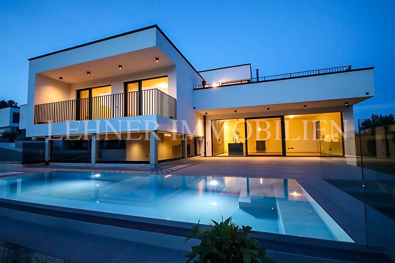 Moderne Villa mit Balkon und Pool in der Dämmerung