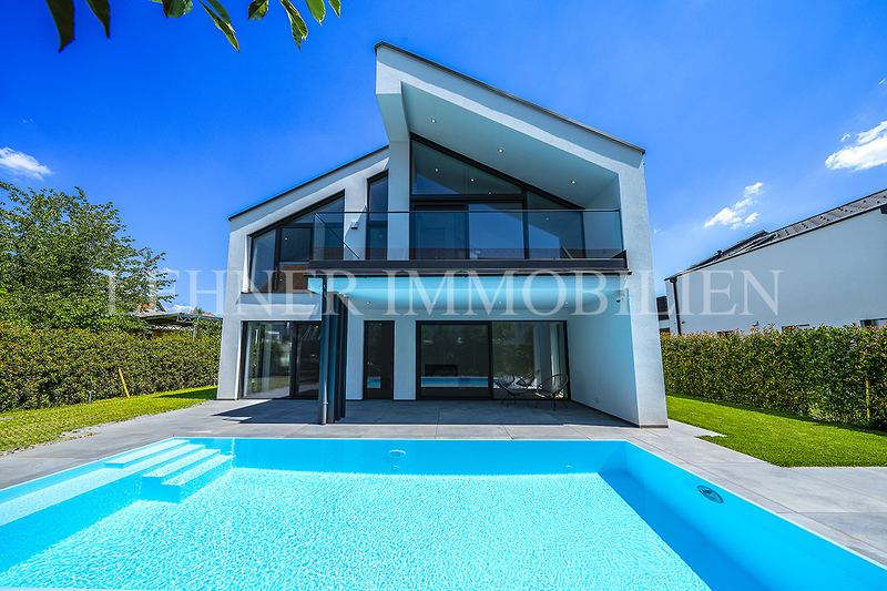 Villa mit Giebel und Glasfront, davor ein Pool